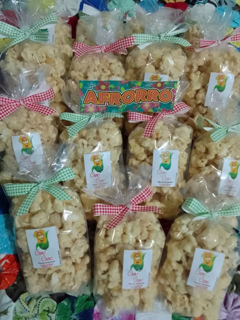 Vários sacos de pipoca dourada com laços xadrez, prontos para entrega.